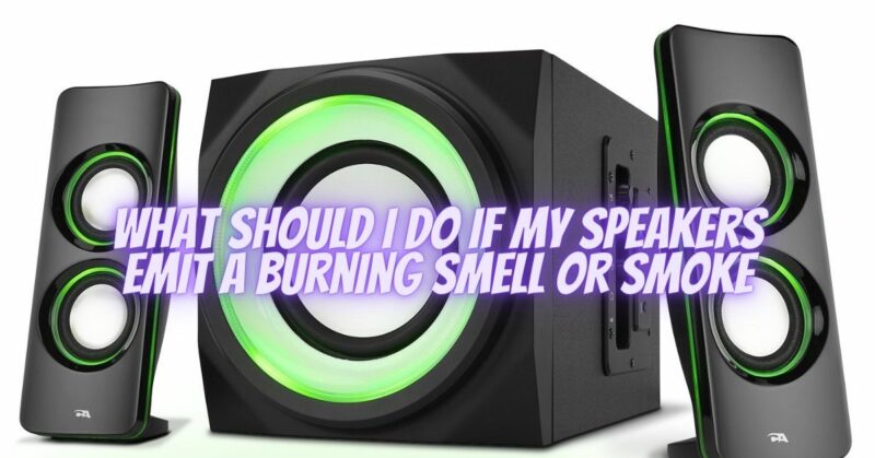 What should I do if my speakers emit a burning smell or smoke