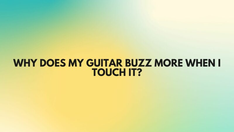 Why does my guitar buzz more when I touch it?