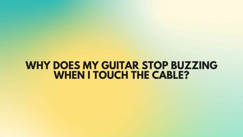 Why does my guitar stop buzzing when I touch the cable?